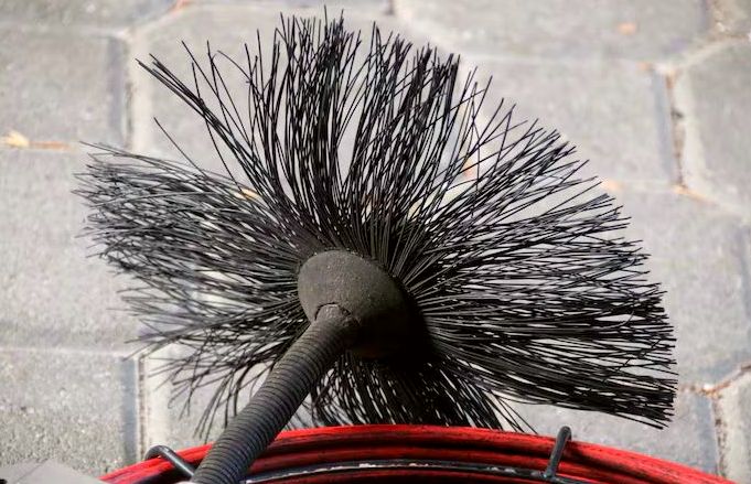 Flue brush head and coiled cable ready for a liner cleaning