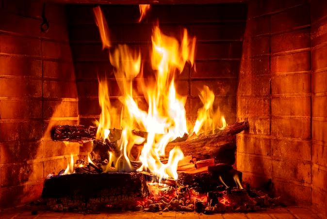 Logs blazing in a well-maintained brick fireplace